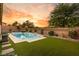 Backyard oasis featuring a pool with spa, synthetic grass, and brick privacy wall at 10086 Mountain Foothills Ave, Las Vegas, NV 89149
