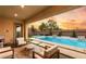 Covered patio with seating overlooking the pool and spa with manicured backyard at 10086 Mountain Foothills Ave, Las Vegas, NV 89149