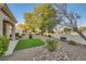 Backyard featuring a patio with a grill, desert landscaping, and mature trees at 10309 Broom Hill Dr, Las Vegas, NV 89134