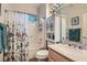 Well-lit bathroom with a shower-tub combination, cabinet, and marble-style countertop at 10309 Broom Hill Dr, Las Vegas, NV 89134