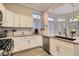 Modern kitchen featuring white cabinetry, stainless steel appliances, and a breakfast bar with sink at 10309 Broom Hill Dr, Las Vegas, NV 89134