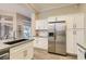 Well-equipped kitchen with stainless steel refrigerator, white cabinets, and a spacious island at 10309 Broom Hill Dr, Las Vegas, NV 89134