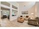 Bright and airy living room with high ceilings, neutral decor, and wood-look tile flooring at 10309 Broom Hill Dr, Las Vegas, NV 89134