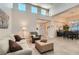 Open-concept living room with high ceilings, wood-look tile floors, and seamless transition to dining area at 10309 Broom Hill Dr, Las Vegas, NV 89134