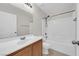 Bathroom featuring a single sink vanity, tile floors, and tub with white tile surround at 11164 African Sunset St, Henderson, NV 89052
