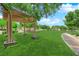 Well-maintained common area with green grass and a covered pergola sitting area, creating a park-like setting at 11164 African Sunset St, Henderson, NV 89052