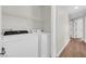 Bright laundry room with modern appliances and access to a hallway with several doors at 11164 African Sunset St, Henderson, NV 89052