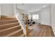 Elegant staircase leading to a living space with wood floors, cozy sofa, and natural light streaming through windows at 11164 African Sunset St, Henderson, NV 89052