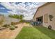 Spacious backyard offers artificial turf, an outdoor dining area, and low maintenance desert landscaping at 1401 Cattail Falls St, Boulder City, NV 89005