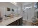 Bathroom with double sinks, vanity, window, and glass shower at 1401 Cattail Falls St, Boulder City, NV 89005