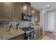 A modern kitchen featuring stainless steel appliances, granite countertops, and stylish cabinetry at 1401 Cattail Falls St, Boulder City, NV 89005