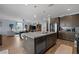 Open-concept kitchen featuring an island with sink, stainless steel appliances, and an adjacent living space at 1401 Cattail Falls St, Boulder City, NV 89005