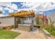 Backyard spa area featuring a covered pergola, lush landscaping, and artificial turf at 1401 Cattail Falls St, Boulder City, NV 89005