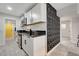 Modern kitchen with white cabinetry, black countertops, stainless steel appliances, and a textured geometric accent wall at 1708 Poplar Ave, Las Vegas, NV 89101