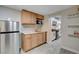 Modern kitchen features wood cabinets, stainless steel refrigerator and stylish gray wood-look tile flooring at 1708 Poplar Ave, Las Vegas, NV 89101