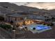 Spacious backyard featuring a pool, spa, fire pit, covered patio, and desert landscape at 2 Olympia Outlook Dr, Las Vegas, NV 89141