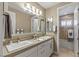 Well-lit bathroom featuring double sinks, large mirrors and a shower and tub combo at 2 Olympia Outlook Dr, Las Vegas, NV 89141