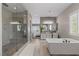 Spacious bathroom featuring walk-in shower, soaking tub, double vanity, and natural light at 2 Olympia Outlook Dr, Las Vegas, NV 89141