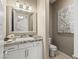 Stylish powder room featuring a modern vanity with granite countertop, decorative mirror and contemporary finishes at 2 Olympia Outlook Dr, Las Vegas, NV 89141