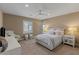 Relaxing bedroom with carpeted floors, ceiling fan, and large windows with natural light at 2 Olympia Outlook Dr, Las Vegas, NV 89141