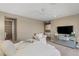 Comfortable bedroom features carpet floors, ceiling fan, large dresser with TV, and an adjoining bathroom at 2 Olympia Outlook Dr, Las Vegas, NV 89141