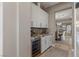 Elegant butler's pantry featuring granite countertop, wine fridge, and white cabinetry at 2 Olympia Outlook Dr, Las Vegas, NV 89141