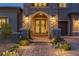 Elegant front entrance featuring a stone archway, double doors with decorative wreaths, and attractive exterior lighting at 2 Olympia Outlook Dr, Las Vegas, NV 89141