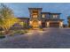 Beautiful two-story home featuring manicured landscaping, a spacious three-car garage, and a welcoming brick driveway at 2 Olympia Outlook Dr, Las Vegas, NV 89141