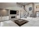 Open concept living space with fireplace, media center, and grand staircase to the upper level at 2 Olympia Outlook Dr, Las Vegas, NV 89141