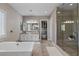 Bright main bathroom featuring a soaking tub, glass enclosed shower, and dual vanities at 2 Olympia Outlook Dr, Las Vegas, NV 89141