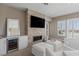 Cozy seating area with a stacked stone fireplace, TV, and wet bar in the main bedroom at 2 Olympia Outlook Dr, Las Vegas, NV 89141