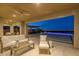 Cozy outdoor patio with plush seating and stunning city skyline views at dusk at 2 Olympia Outlook Dr, Las Vegas, NV 89141