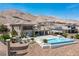 Beautiful rear exterior with a sleek pool, covered patio, and desert landscaping, offering privacy and style at 2 Olympia Outlook Dr, Las Vegas, NV 89141
