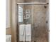 Close up of the tile shower featuring sleek hardware, window and shower products shelf at 2 Olympia Outlook Dr, Las Vegas, NV 89141
