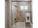 Shower and tub combo featuring a tile shower surround, sleek hardware and window at 2 Olympia Outlook Dr, Las Vegas, NV 89141