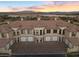 Beautiful building featuring garages and tile roofing, set against the backdrop of a serene lake at 20 Via Visione # 104, Henderson, NV 89011