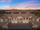 Exterior shot of a multi-unit building with garages at sunset near a lake at 20 Via Visione # 104, Henderson, NV 89011