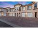 Townhouse exterior with multiple garages and brick driveway at 20 Via Visione # 104, Henderson, NV 89011