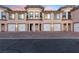 Townhouse exterior showcasing multiple garages, architectural detail, and brick driveway at 20 Via Visione # 104, Henderson, NV 89011