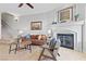 Open concept living room with fireplace, tile floors, stairs, modern furniture, and neutral tones at 20 Via Visione # 104, Henderson, NV 89011