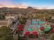 Community pool with cabanas, palm trees, and mountain views at sunrise at 20 Via Visione # 104, Henderson, NV 89011