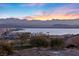 Vibrant sunset view overlooking the tranquil lake, with striking mountain views in the distance at 20 Via Visione # 104, Henderson, NV 89011