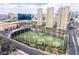 An aerial view of the driving range, surrounding buildings, and city skyline near this resort-style property at 205 E Harmon Ave # 409, Las Vegas, NV 89169