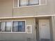 Two-story townhouse featuring neutral siding, a front door, and visible window details at 2574 Paradise Village Way, Las Vegas, NV 89120