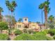 Community clubhouse surrounded by lush desert landscaping, towering palm trees and clear skies at 270 E Flamingo Rd # 214, Las Vegas, NV 89169