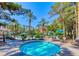 Inviting in-ground hot tub surrounded by lounge seating and mature trees at 270 E Flamingo Rd # 214, Las Vegas, NV 89169