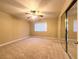 Spacious bedroom with plush carpet, ceiling fan, and sliding mirror closet doors at 2750 S Durango Dr # 1038, Las Vegas, NV 89117