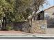 Exterior view of community building with stone wall, mature trees, and unit numbers at 2750 S Durango Dr # 1038, Las Vegas, NV 89117
