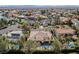Aerial view of home with sparkling pool in a desert community with lush landscaping and mountain views at 2805 High Sail Ct, Las Vegas, NV 89117