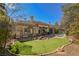 Wide backyard featuring synthetic putting green, tall mature tree cover, pool, and outdoor patio at 2805 High Sail Ct, Las Vegas, NV 89117